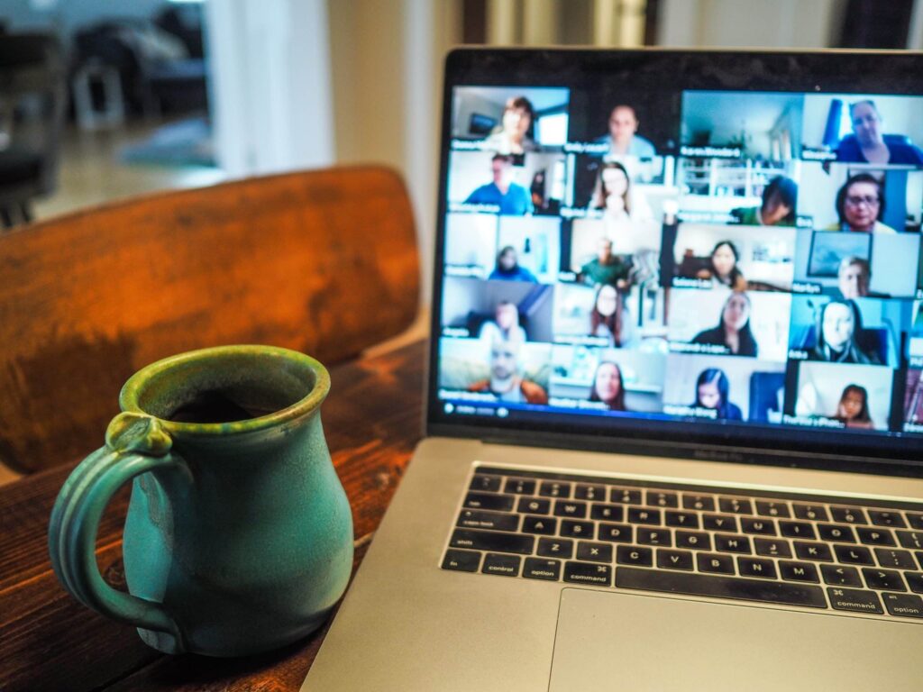 Virtual Press Conference on oom meeting on a MacBook next to a cup of coffee
