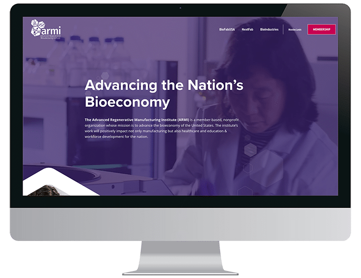 A computer monitor displays a website titled Advancing the Nation’s Bioeconomy with scientists in the background.