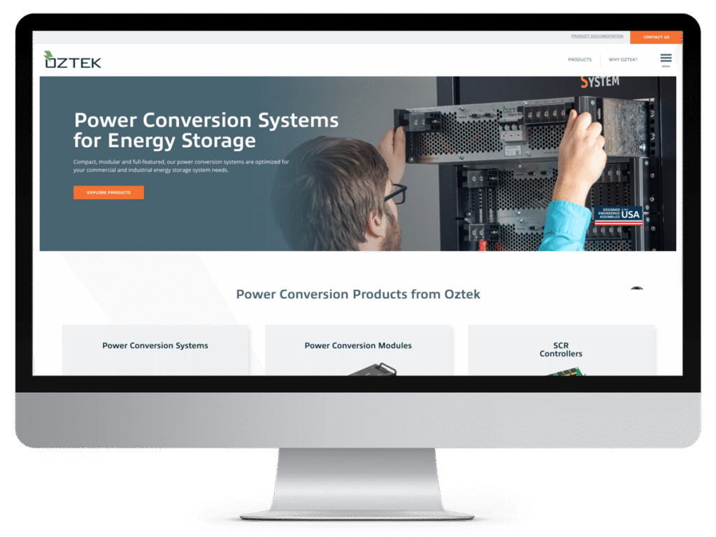 Computer screen displaying Oztek’s manufacturing website design about power conversion systems, with a person installing equipment.