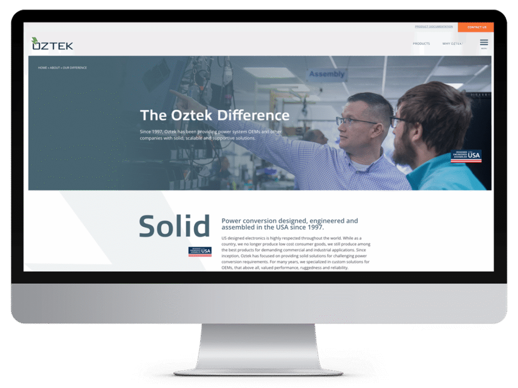 Two men discuss equipment in a factory, highlighting The Oztek Difference and company info, showcased alongside innovative manufacturing website design on the screen.