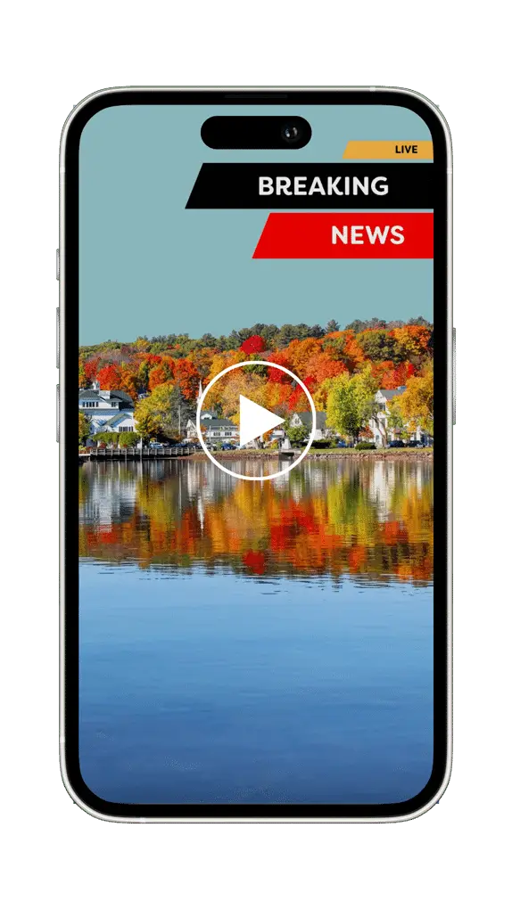A phone screen shows a breaking news alert over a video of a lake with autumn trees and houses in the background, ready to be shared on social media.