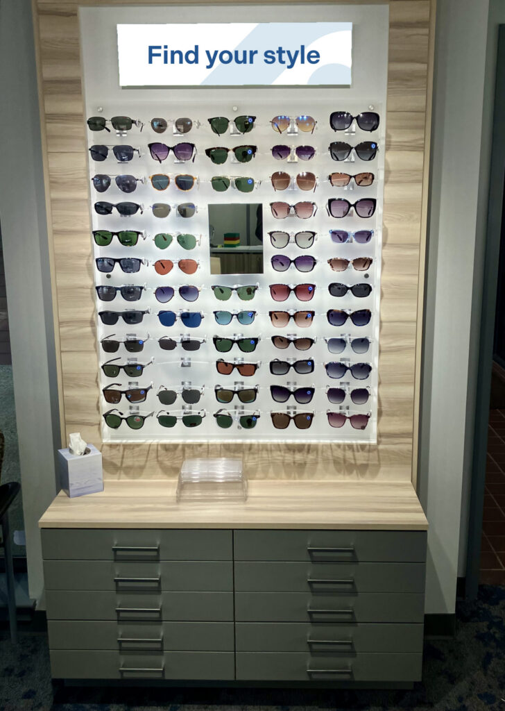 Sunglasses display with various styles and colors, under a sign reading Find your style.
