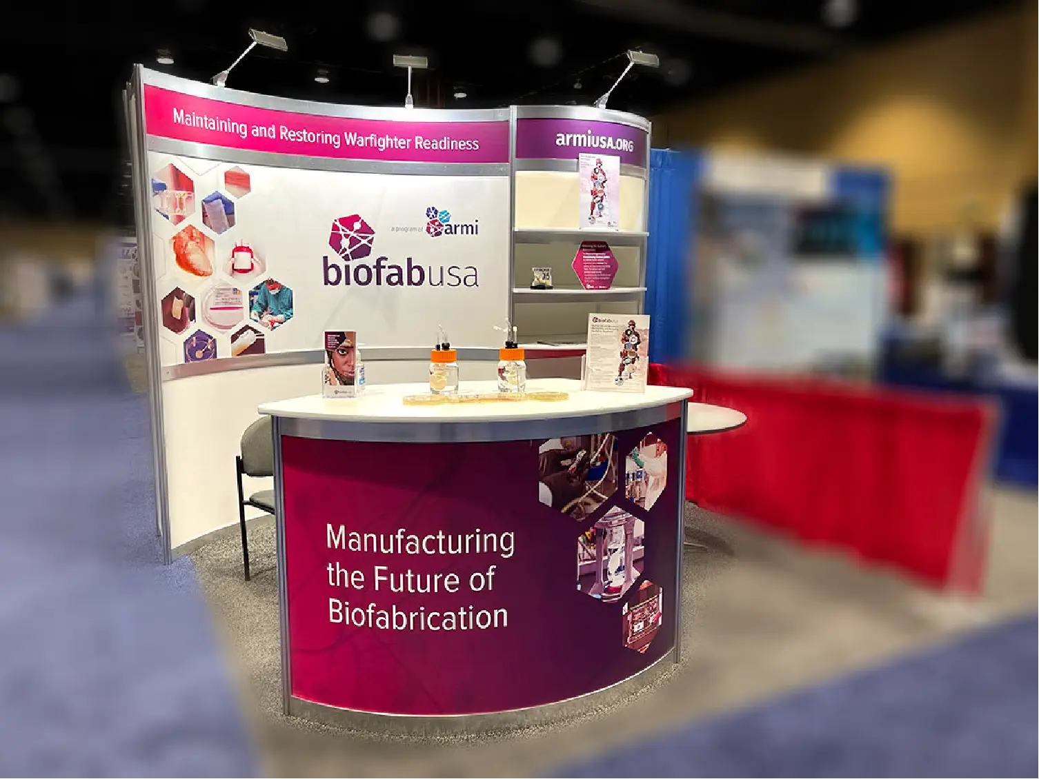 BiofabUSA trade show booth with banners and brochures on biofabrication and warfighter readiness.
