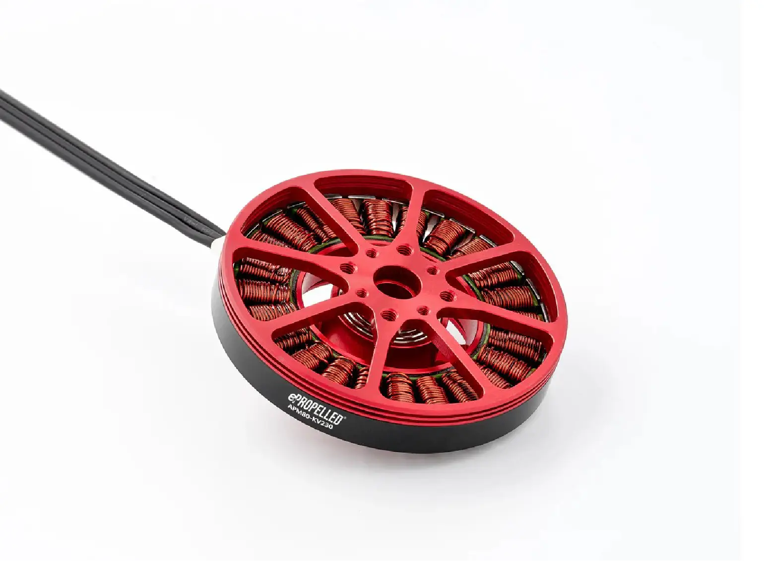 A red and black electric motor with exposed copper coils and wires on a white background.